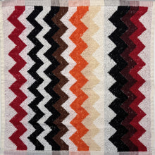 Load image into Gallery viewer, Textile with zigzag pattern in red, black, white, and beige on a checkered fabric background